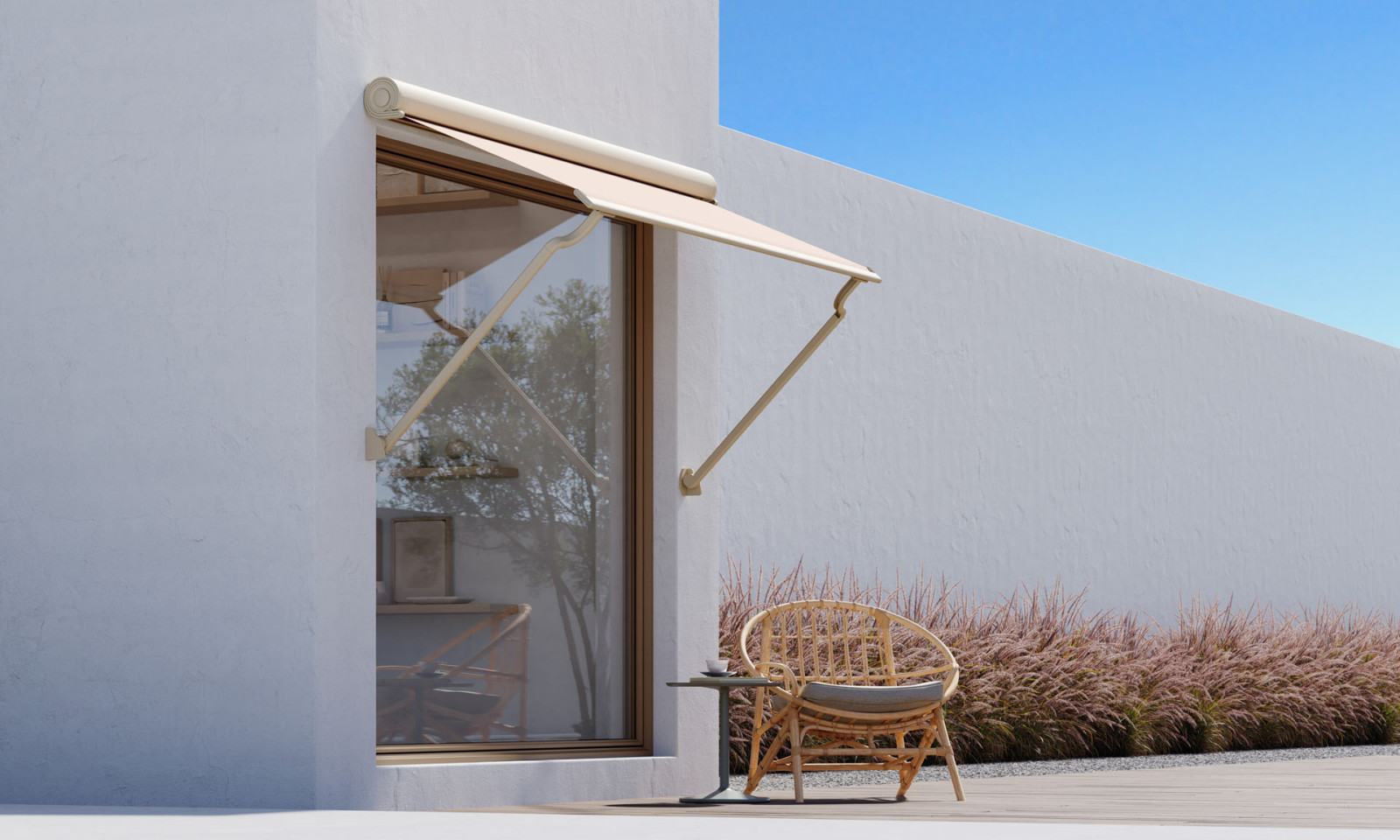 White house with wooden deck, modern looking awning and and patio, surrounded by greenery.