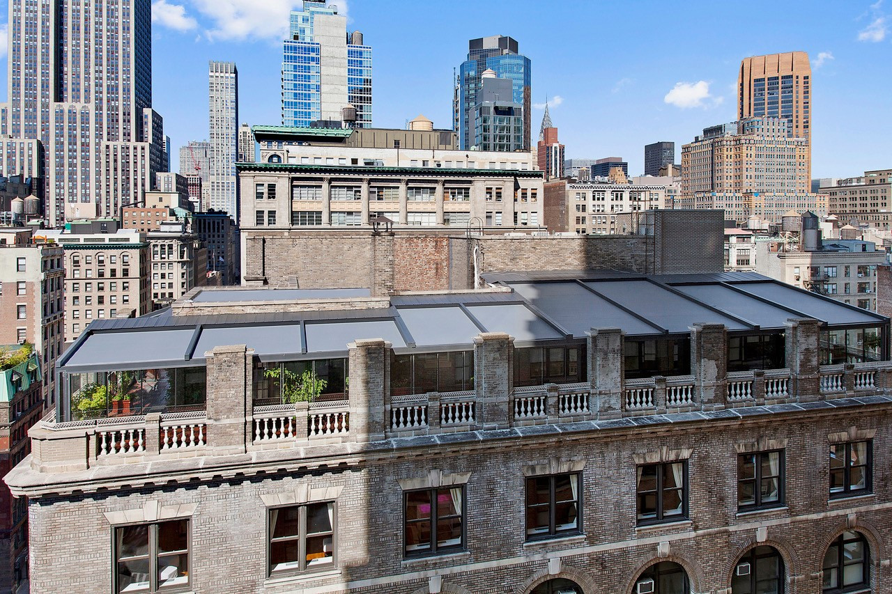 Palmiye Global pergola systems installed on a rooftop terrace, offering a stylish and functional solution for year-round outdoor living in an urban environment, with a stunning city skyline in the background.