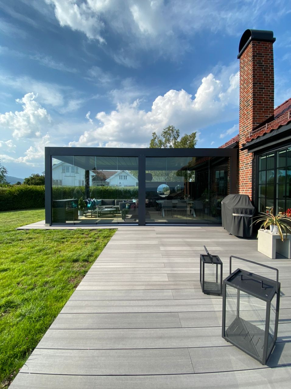 Stylish home showcasing a generous deck, fire pit, and a retractable pergola for enhanced weather compatibility.