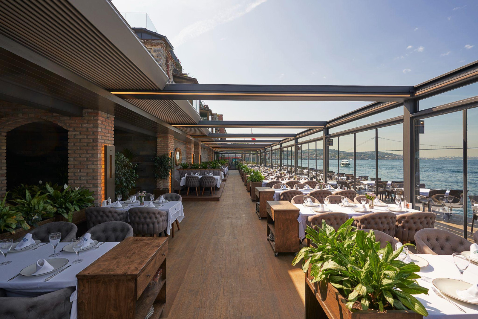 Rooftop restaurant featuring tables and chairs with a scenic view of the water, enhanced by elegant pergola solutions.