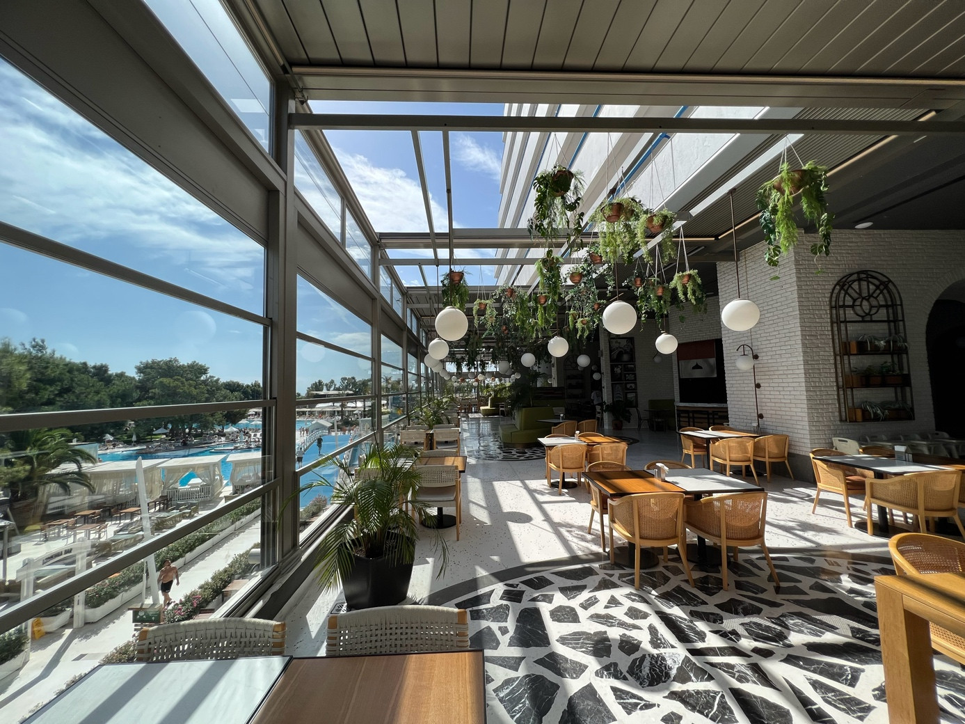 Rooftop restaurant featuring tables and chairs under a Palmiye Global pergola system, offering outdoor dining.