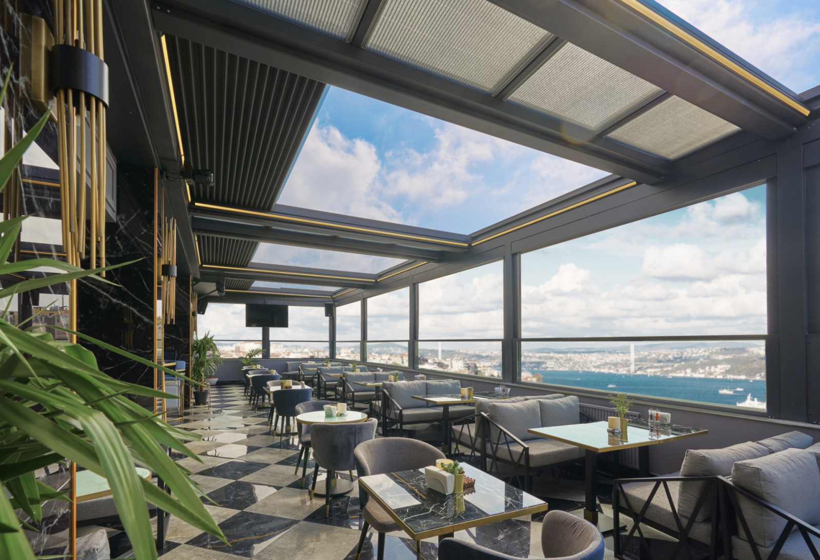 Rooftop bar at the hotel featuring a panoramic view of the city skyline, showcasing Bioclimatic Systems by Palmiye Global.