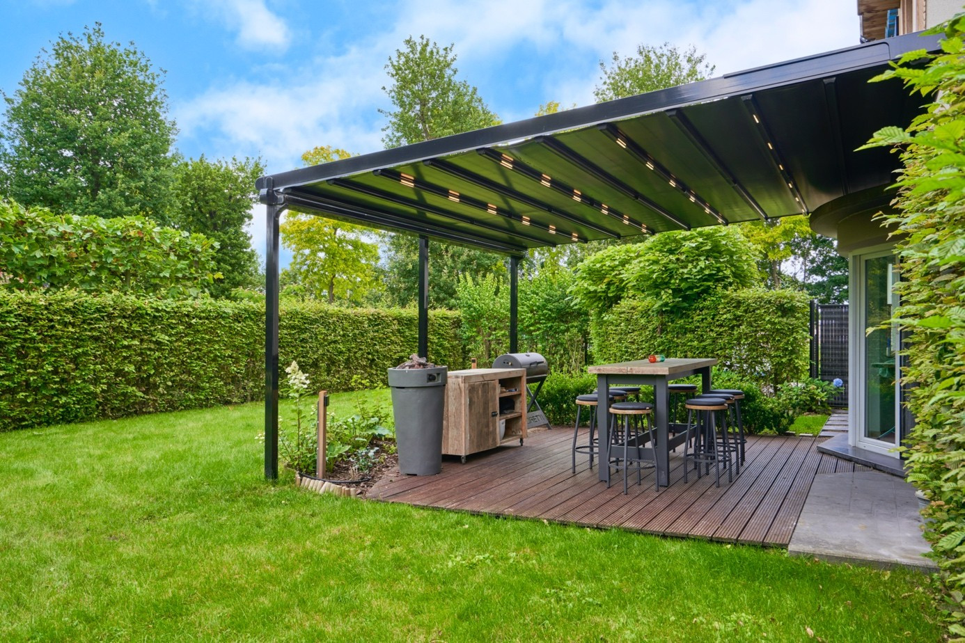 Modern pergola system on a garden terrace with deck flooring and an outdoor seating area