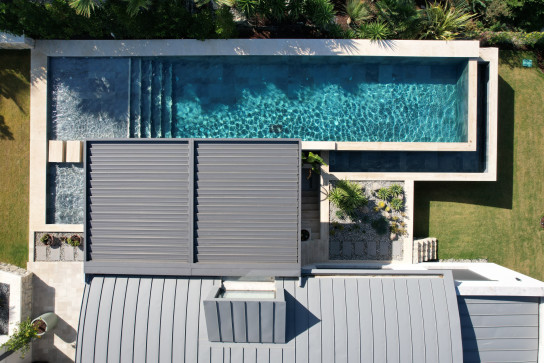 Modern aluminum pergola system by the pool, enhancing outdoor comfort and architectural aesthetics