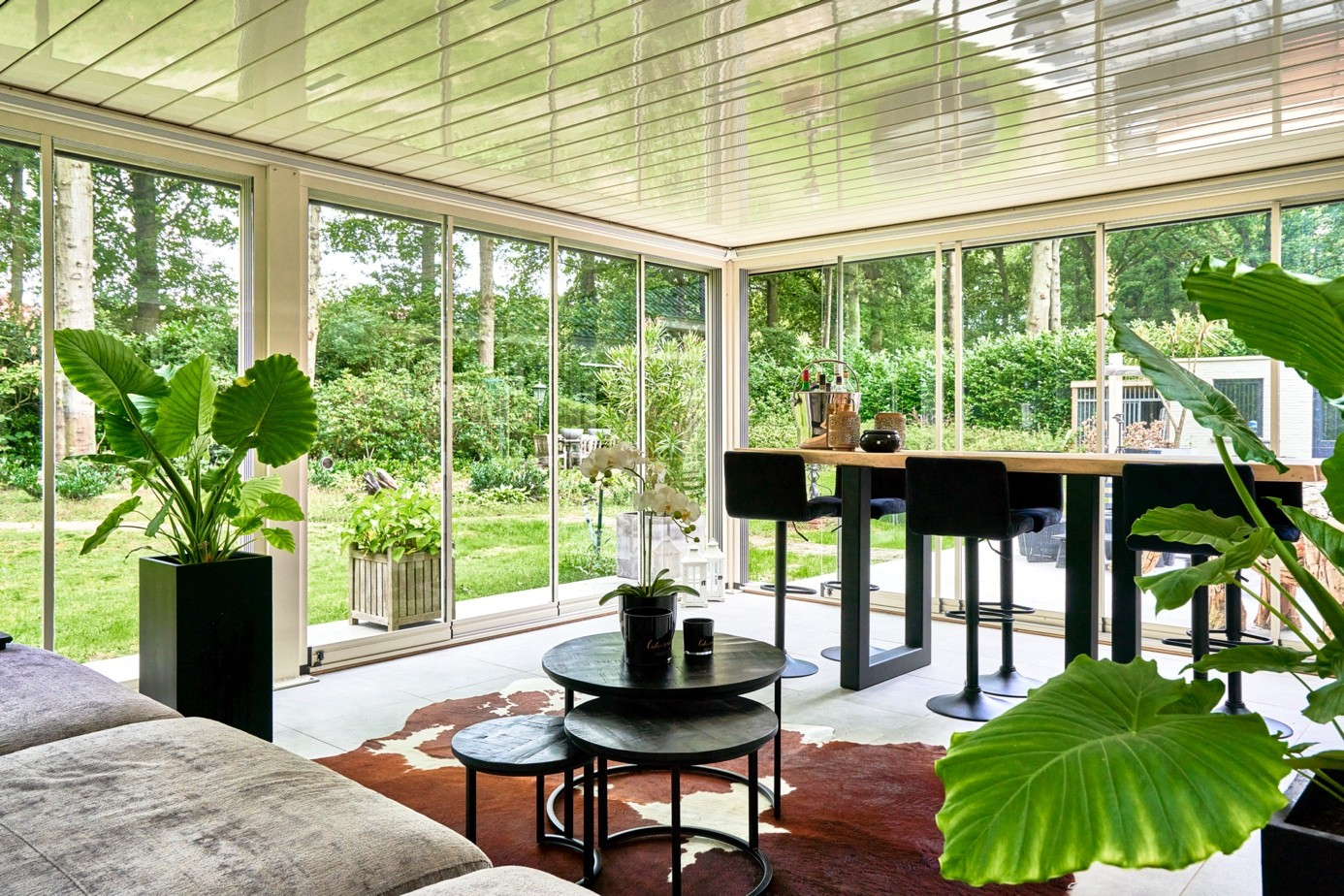 Glass-enclosed terrace pergola system creating a comfortable outdoor living space for year-round use