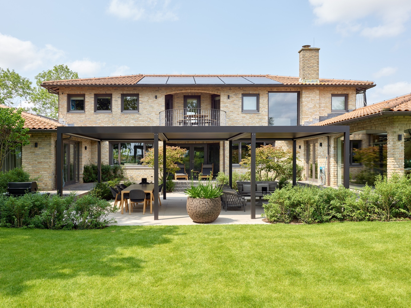Modern pergola shading system extending a villa garden into a comfortable outdoor living space