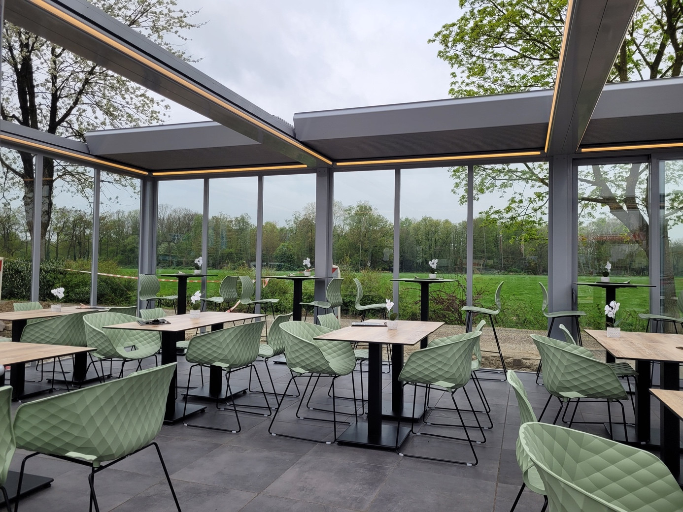 Motorized pergola and glass facade system for a four-season café and restaurant outdoor area