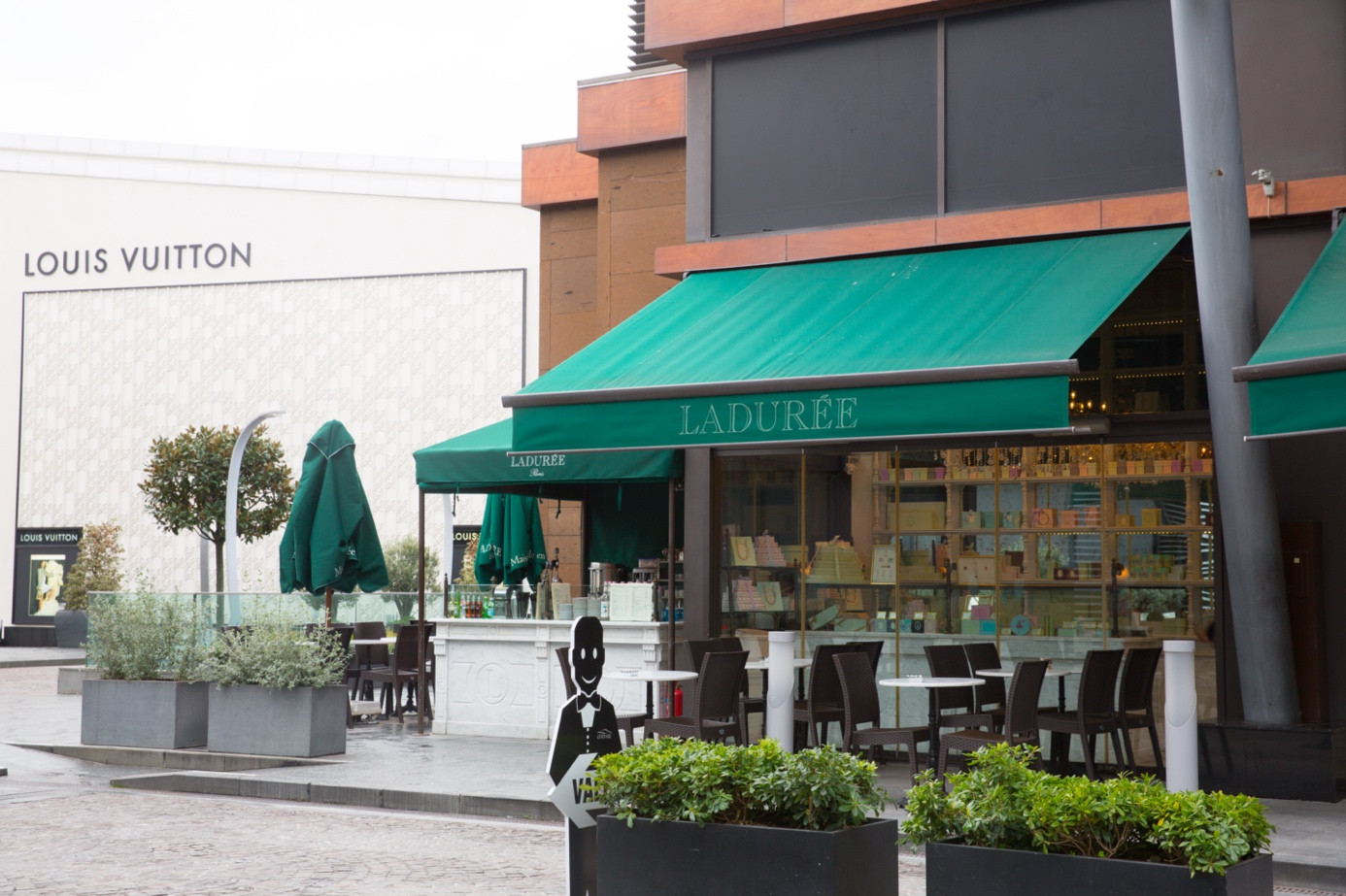 Exterior awning selection example with a green retractable awning integrated into a modern commercial façade